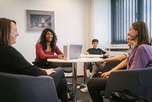 Professorin und Studierende sitzen zusammen an einem Tisch